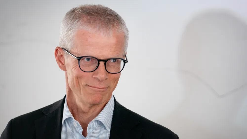 Portrett av Hans Christian Holte med briller og mørk dressjakke