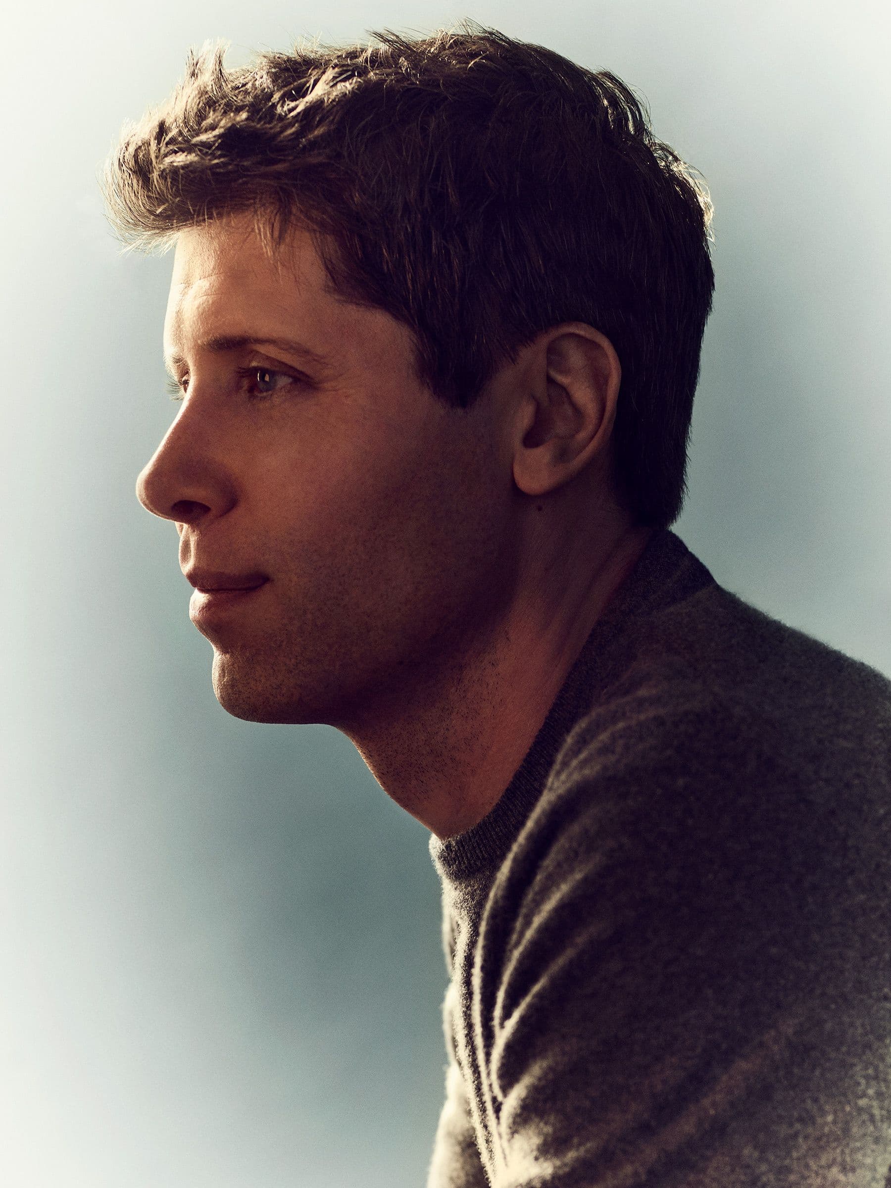 Sam Altman i profil mot mørk bakgrunn